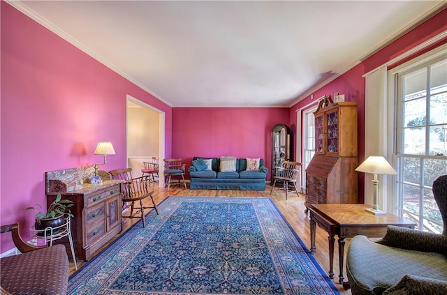 sitting room featuring plenty of natural light, ornamental molding, and wood-type flooring