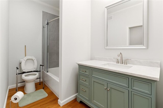 5150 Wheat St NE, Covington, GA 30014 - full bath featuring toilet, vanity, wood finished floors,  shower combination, and crown molding