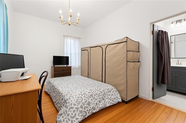 5150 Wheat St NE, Covington, GA 30014 - bedroom featuring light wood-style flooring, a chandelier, and a sink