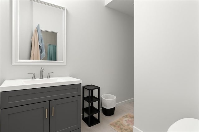 5150 Wheat St NE, Covington, GA 30014 - full bath with vanity, baseboards, toilet, and wood finished floors