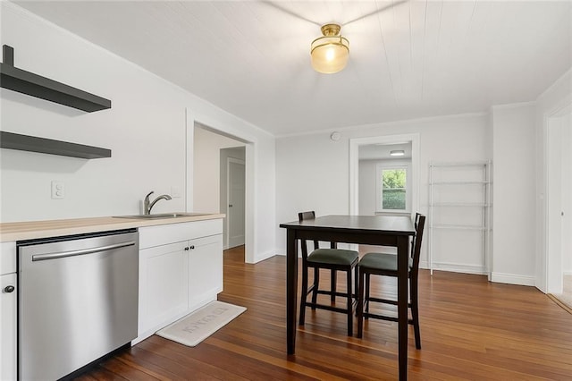 5150 Wheat St NE, Covington, GA 30014 - kitchen featuring stainless steel dishwasher, a sink, open shelves, dark wood-style flooring, and white cabinetry