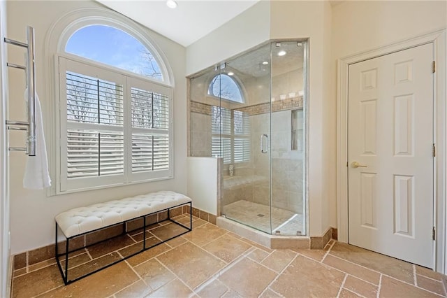 full bathroom with stone tile floors, recessed lighting, a stall shower, and baseboards