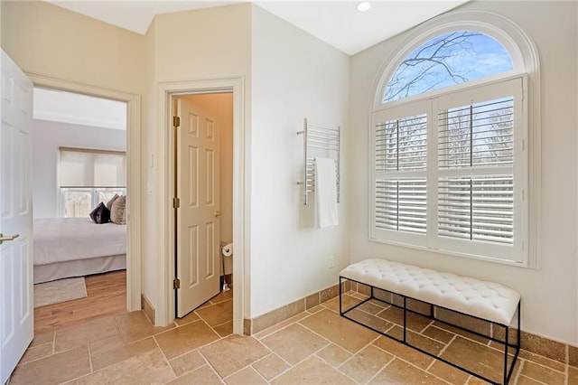 hallway with baseboards and stone tile floors