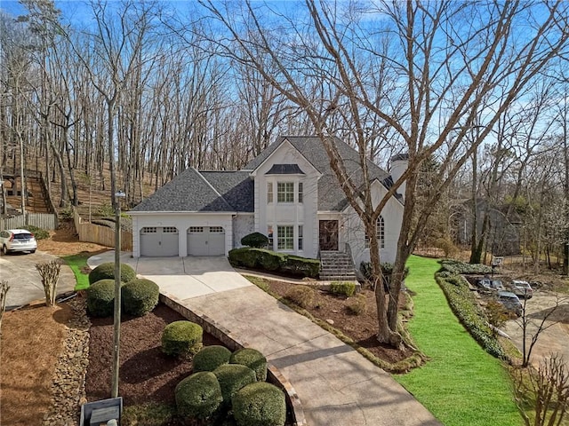 view of front of home featuring fence, roof with shingles, concrete driveway, an attached garage, and a chimney