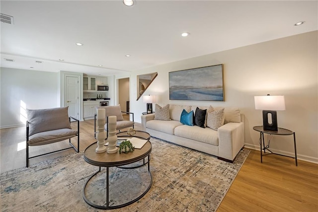 living area featuring recessed lighting, visible vents, and light wood finished floors