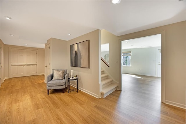 living area with stairs, recessed lighting, light wood-style floors, and baseboards