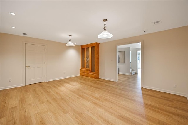 unfurnished room with visible vents, baseboards, and light wood-style floors