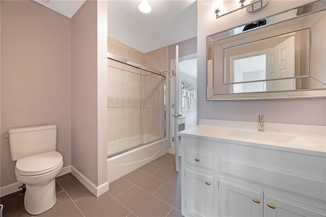 full bathroom featuring tile patterned flooring, enclosed tub / shower combo, toilet, and vanity