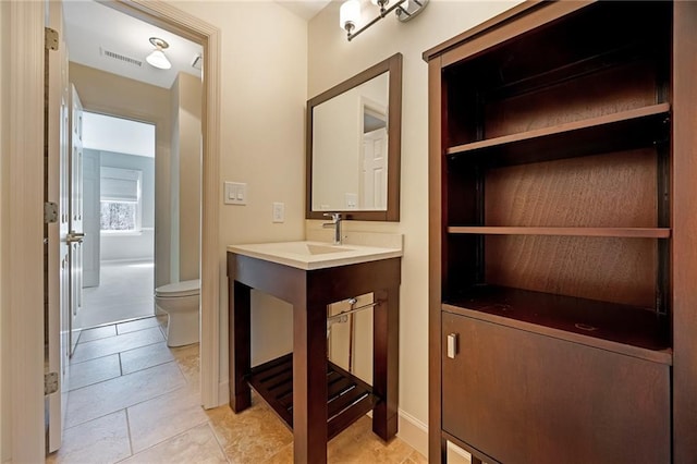 bathroom featuring vanity, toilet, visible vents, and tile patterned flooring