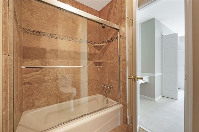 bathroom with baseboards and bath / shower combo with glass door