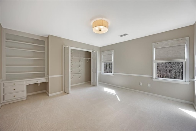 unfurnished bedroom featuring visible vents, baseboards, carpet, and a closet