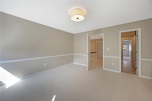 unfurnished bedroom featuring baseboards and light carpet