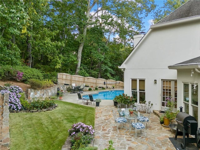 exterior space featuring a patio, fence, a yard, a grill, and a fenced in pool