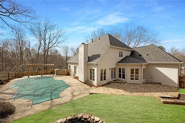 back of house featuring stucco siding, a fenced backyard, and a chimney