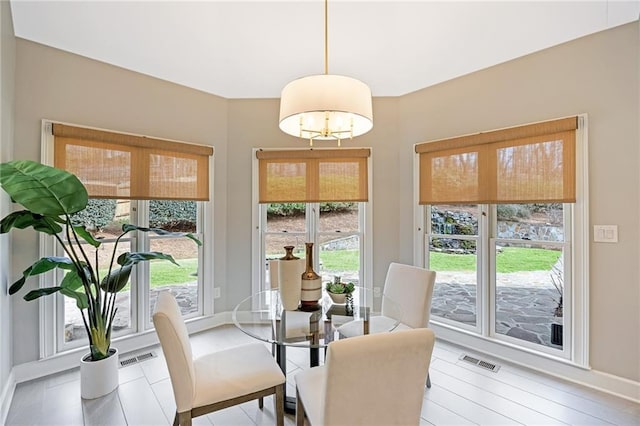 dining area with visible vents, a wealth of natural light, and a chandelier