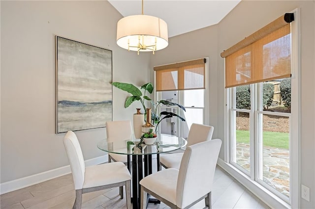 dining area featuring baseboards and a chandelier