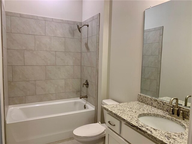 full bathroom featuring tiled shower / bath combo, vanity, and toilet