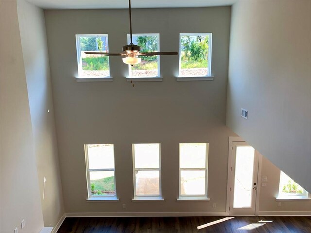 unfurnished living room featuring a healthy amount of sunlight and dark hardwood / wood-style floors