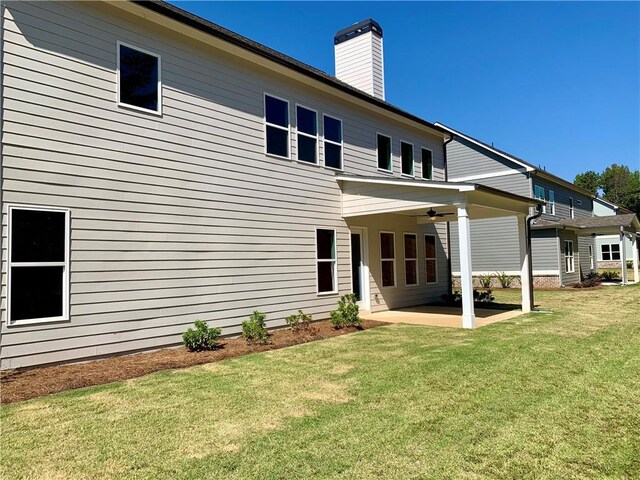 rear view of house with a yard and a patio area