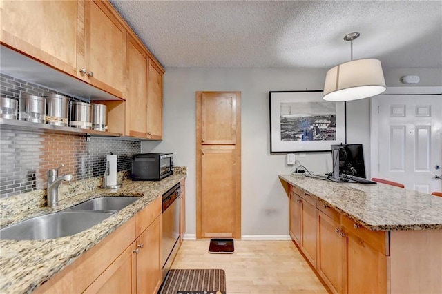 kitchen with light wood-style flooring, backsplash, a sink, dishwasher, and a peninsula