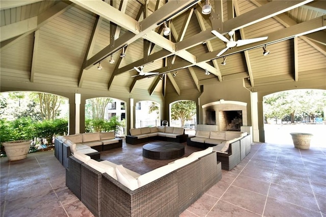 view of patio / terrace featuring ceiling fan and an outdoor living space with a fireplace