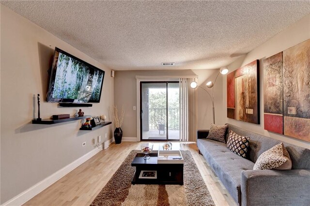 living room with hardwood / wood-style flooring and a textured ceiling