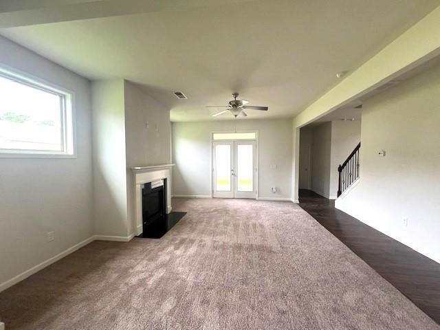 2469 Osceola Rd, Lithonia, GA 30058 - unfurnished living room featuring a fireplace, a ceiling fan, stairway, carpet flooring, and french doors