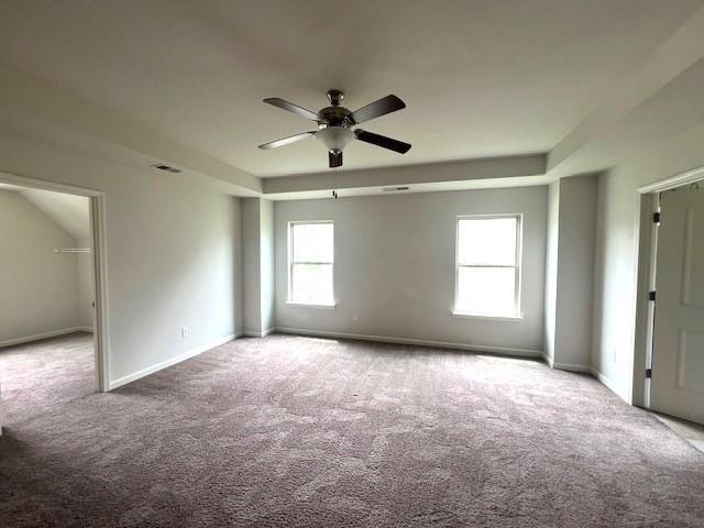 2469 Osceola Rd, Lithonia, GA 30058 - carpeted spare room with a raised ceiling, plenty of natural light, a ceiling fan, and baseboards
