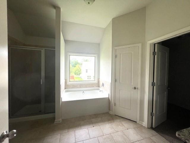 2469 Osceola Rd, Lithonia, GA 30058 - bathroom featuring a bath, a shower stall, vaulted ceiling, and tile patterned flooring
