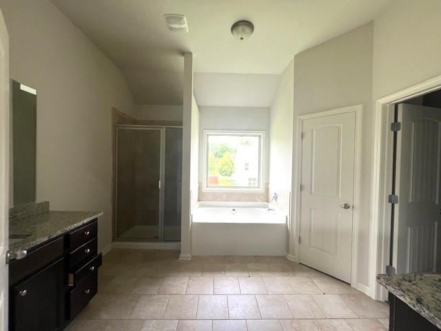 2469 Osceola Rd, Lithonia, GA 30058 - full bathroom with vanity, a garden tub, a stall shower, tile patterned floors, and vaulted ceiling