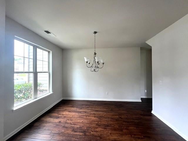 2469 Osceola Rd, Lithonia, GA 30058 - unfurnished dining area with dark wood finished floors, a chandelier, and baseboards