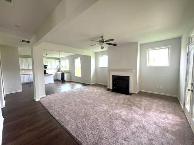 2469 Osceola Rd, Lithonia, GA 30058 - unfurnished living room featuring a ceiling fan, baseboards, a fireplace with flush hearth, and dark wood-type flooring