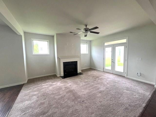 2469 Osceola Rd, Lithonia, GA 30058 - unfurnished living room featuring a fireplace with flush hearth, ceiling fan, baseboards, french doors, and carpet