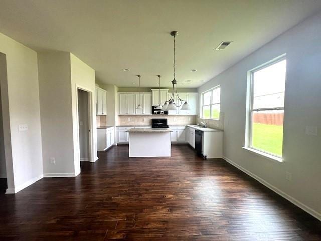 2469 Osceola Rd, Lithonia, GA 30058 - kitchen with black dishwasher, a kitchen island, dark wood-style flooring, and a sink