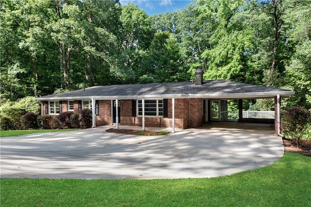 ranch-style house featuring driveway, a chimney, an attached carport, and brick siding