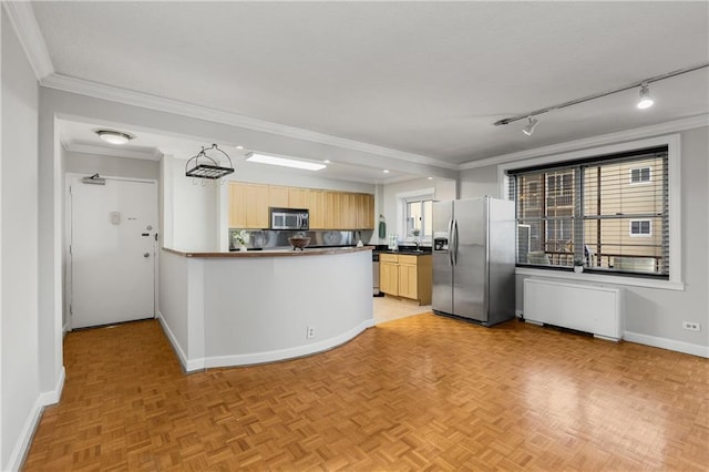 kitchen with dark countertops, a healthy amount of sunlight, stainless steel appliances, and ornamental molding