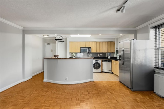 kitchen with washer / dryer, a textured ceiling, stainless steel appliances, and crown molding