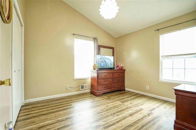 bedroom with light hardwood / wood-style floors, a closet, and lofted ceiling