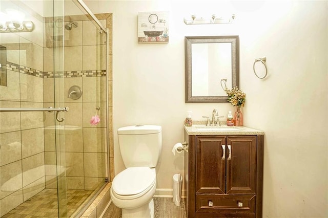 bathroom with toilet, vanity, and walk in shower