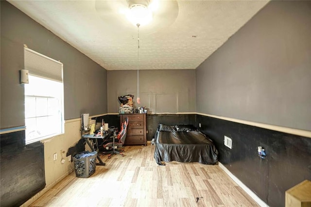 bathroom with a textured ceiling, hardwood / wood-style flooring, and ceiling fan