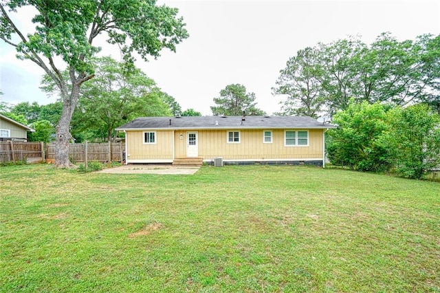 back of house featuring a lawn and central air condition unit