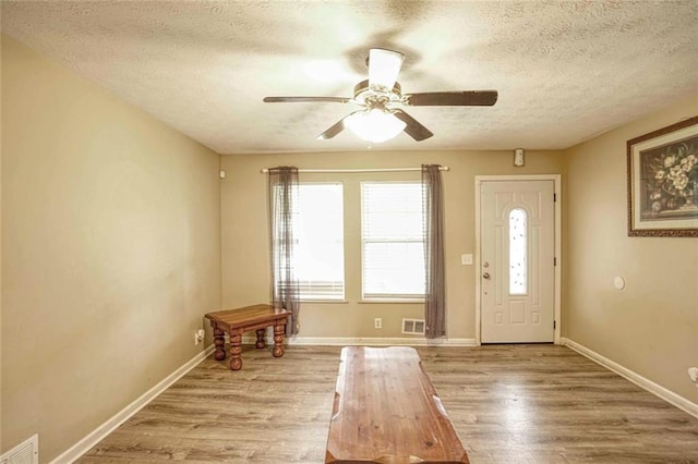 entrance foyer with ceiling fan, light wood-type flooring, and a textured ceiling