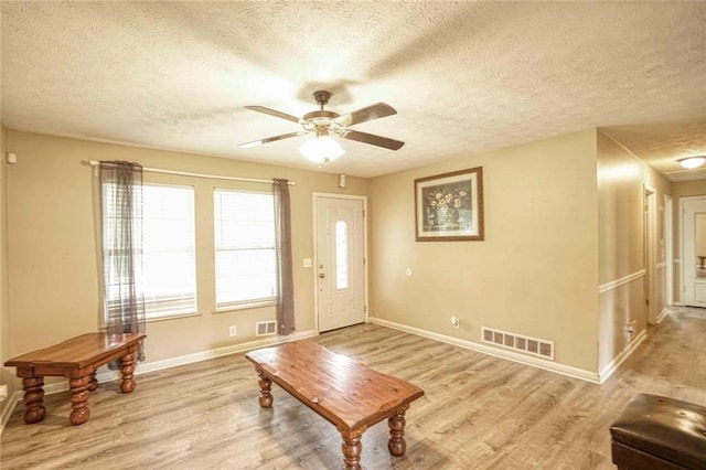 entrance foyer with a textured ceiling, light hardwood / wood-style floors, and ceiling fan