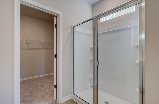 bathroom featuring a shower with door