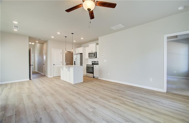 unfurnished living room with ceiling fan, sink, and light hardwood / wood-style floors