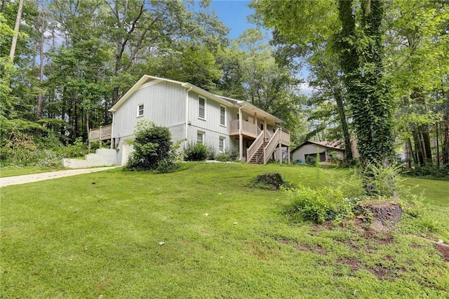 537 Raven Springs Trl, Stone Mountain, GA 30087 - view of front facade with stairs, a front lawn, concrete driveway, an attached garage, and a deck