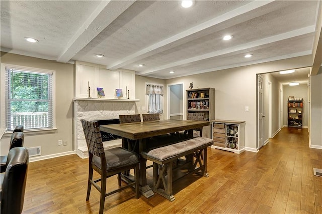 537 Raven Springs Trl, Stone Mountain, GA 30087 - dining space with beam ceiling, wood finished floors, a fireplace, a textured ceiling, and recessed lighting