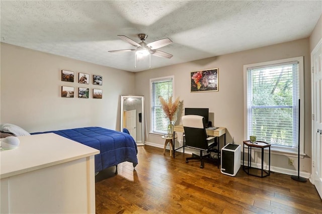 537 Raven Springs Trl, Stone Mountain, GA 30087 - bedroom featuring dark wood-style flooring, multiple windows, a desk, a textured ceiling, and ceiling fan