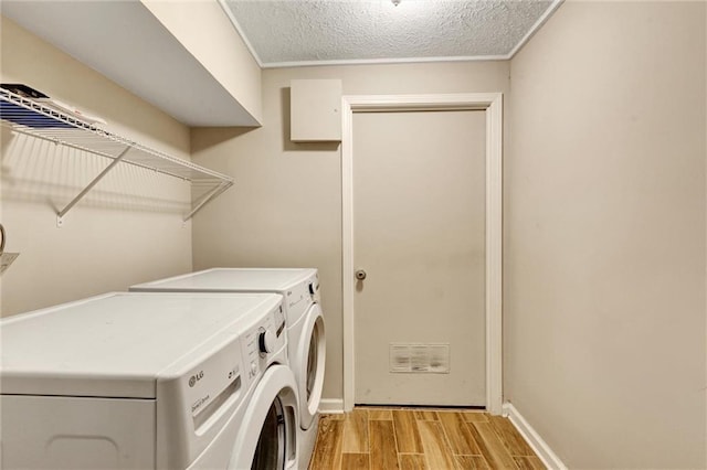537 Raven Springs Trl, Stone Mountain, GA 30087 - washroom with independent washer and dryer, light wood-style floors, and a textured ceiling