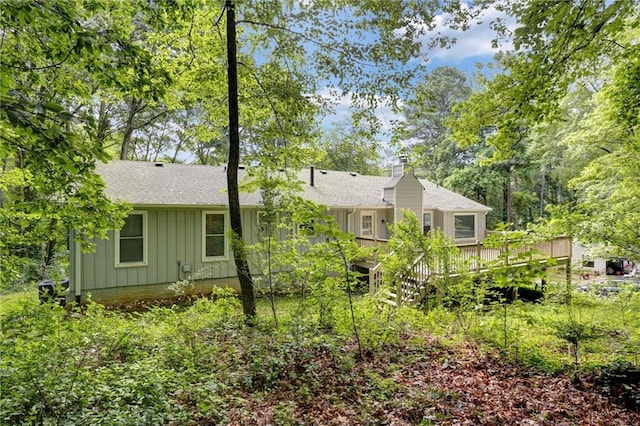 537 Raven Springs Trl, Stone Mountain, GA 30087 - back of property with board and batten siding, a chimney, a deck, and roof with shingles